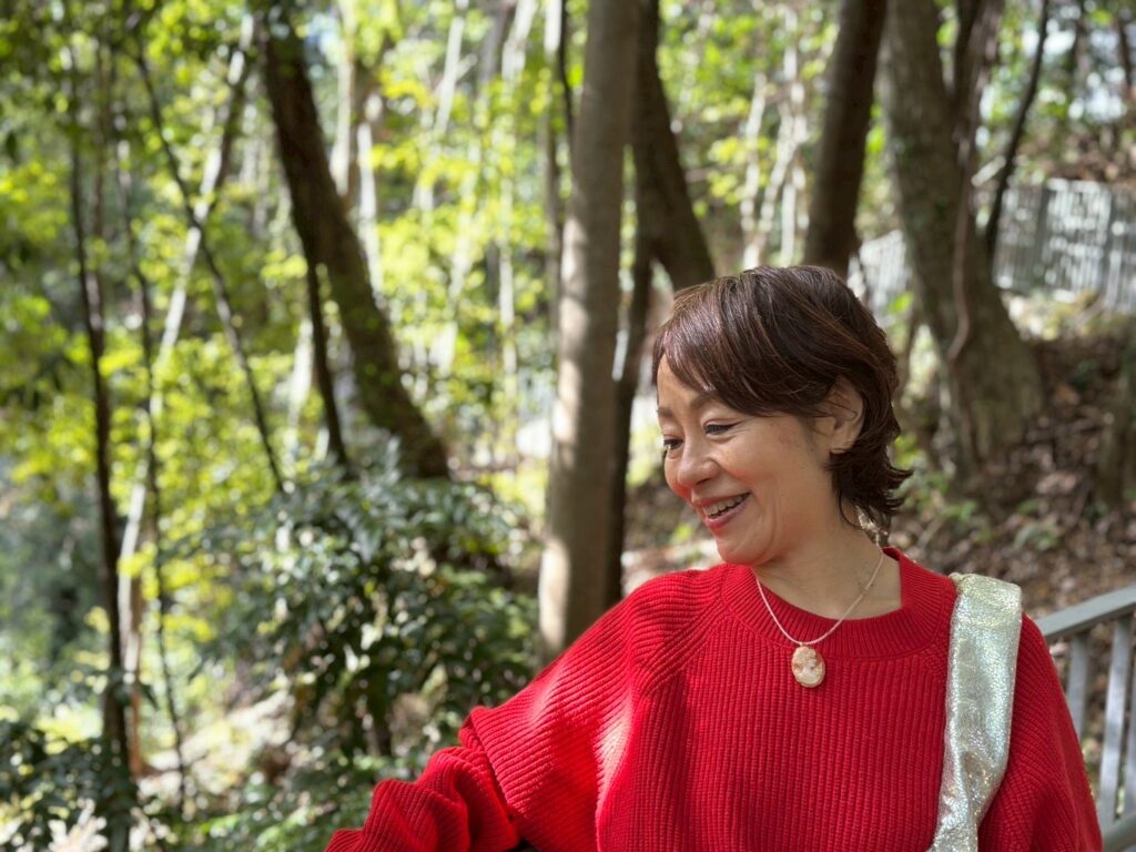 海を眺めながらお金の循環と愛のつながりに気づく女性のイメージ写真