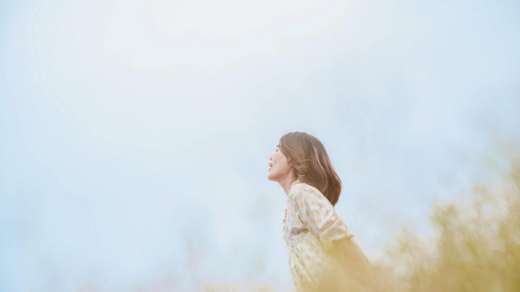 草原で深呼吸している女性の写真