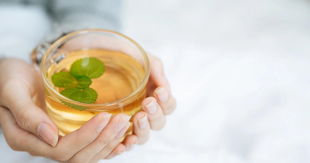 ハーブティーを飲む女性の手