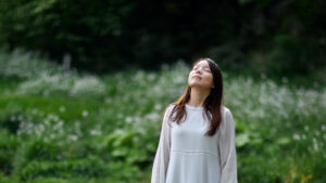 草原で深呼吸をする女性