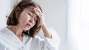 頭痛で辛そうな女性 更年期・片頭痛・自律神経系