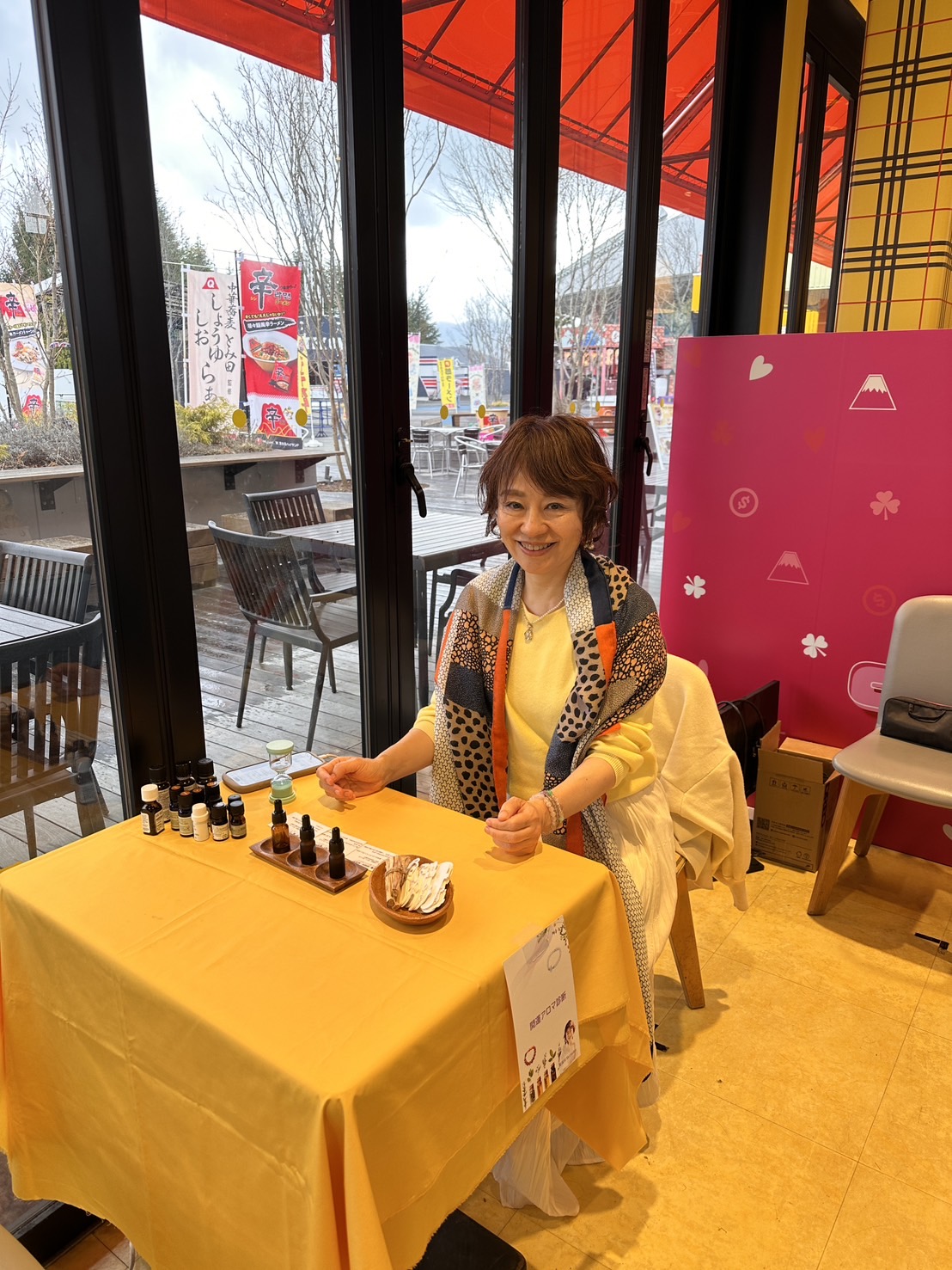 開運アロマ診断の出展ブースで笑顔のセラピストとアロマオイル