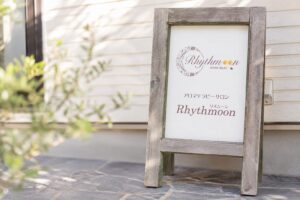 リズムーンの木製看板。アロマテラピーサロンRhythmoonのロゴが入ったナチュラルな看板